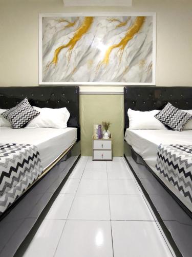 two beds in a room with white floors at Alap Stay-Inn in Candi