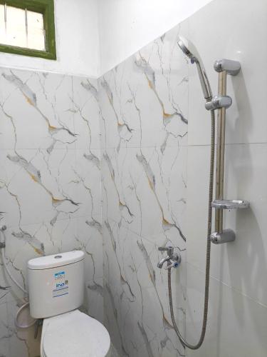 a bathroom with a toilet and a shower at Alap Stay-Inn in Candi