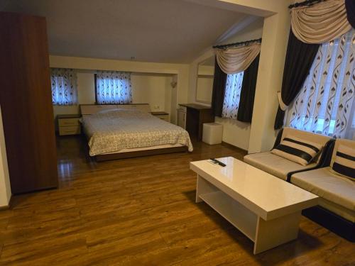 a large bedroom with a bed and a couch at Стаи за гости Дани in Zlatograd