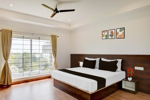 a bedroom with a large bed and a window at Super Collection O Nandagokula Convention Centre Formerly Arasu Comforts in Hassan
