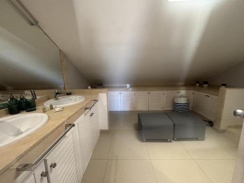 a bathroom with two sinks and a chair in it at Relax Blue Marlin Pasito Blanco in Pasito Blanco