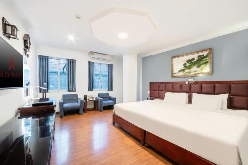a bedroom with a large bed and two chairs at A25 Hotel - 61 Lương Ngọc Quyến in Hanoi