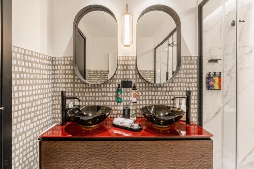 a bathroom with two sinks and two mirrors at Palazzo Rota Luxury Apartments in Venice