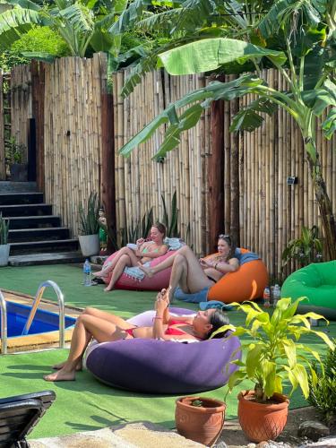 a group of people laying on inflatables by a pool at Hangover Chill & Hill Hostel in Phi Phi Don