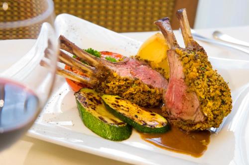 a plate of food with a piece of meat and vegetables at Hotel Blitzburg in Brunico