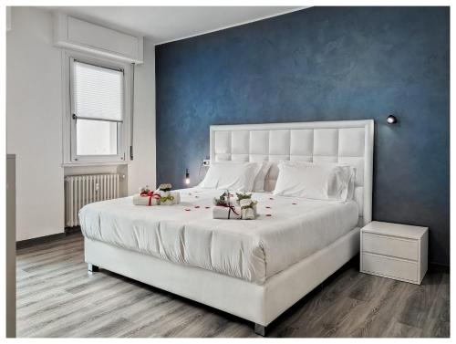 ein Schlafzimmer mit einem großen weißen Bett und einer blauen Wand in der Unterkunft Flats4rent Verona Elegance Luxury Apartment in Verona