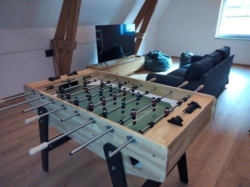 a living room with a foosball table at Les Campanes - Gîte Wellness 8 pers avec Piscine intérieure & Sauna - Proche Mons 