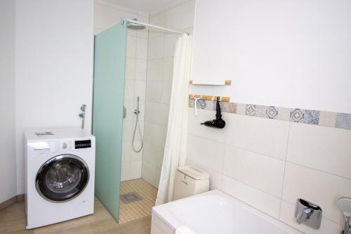 a bathroom with a washing machine and a washer at Marina 24-A in Cuxhaven