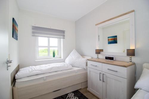 a room with a bench with a mirror and a window at Deichgraf 345 in Döse