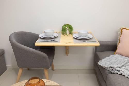 a table with two cups and saucers on it next to a couch at Smart Suites Self Check-in Apartments - S Freney in Brisbane