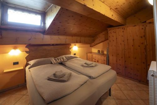 une chambre avec un lit avec des serviettes dessus dans l'établissement Wood Apartment, à Livigno