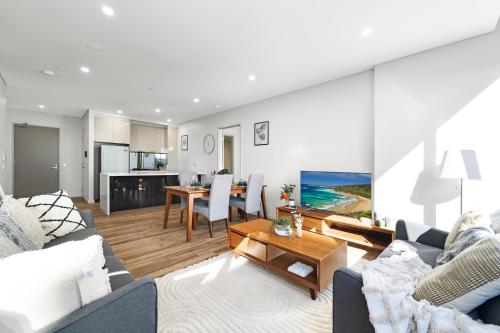a living room with a couch and a table at Prime Mascot 2BR Pool Gym Sauna Access in Sydney
