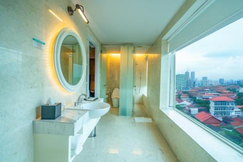 une salle de bain avec un lavabo et une grande fenêtre dans l'établissement De Paviljoen Bandung, à Bandung