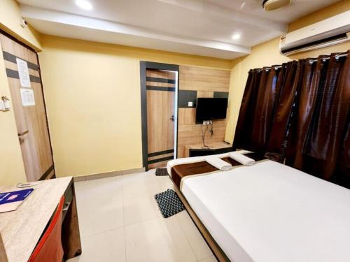 a room with two beds and a tv in it at Hotel Saad in Kolkata