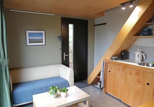 una sala de estar con un sofá y una mesa en Logeerruimte Bij Ton, en Beilen
