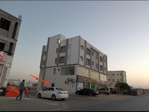 a man throwing a frisbee in front of a building at شقة البشائر in Al Khawḑ