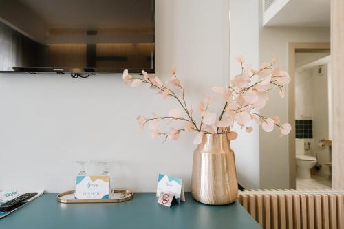 un jarrón lleno de flores rosas sentado en un mostrador en Hotel YVY, en Sebeş