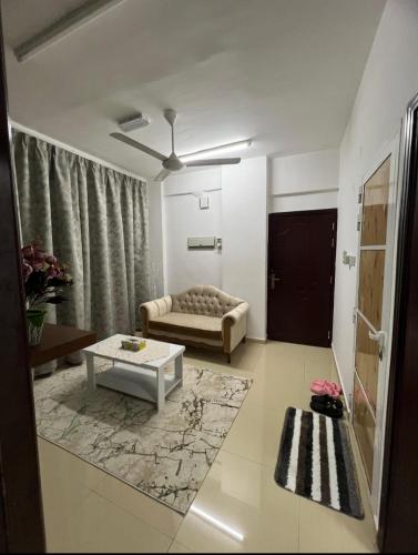 a living room with a couch and a table at شقة البشائر in Al Khawḑ