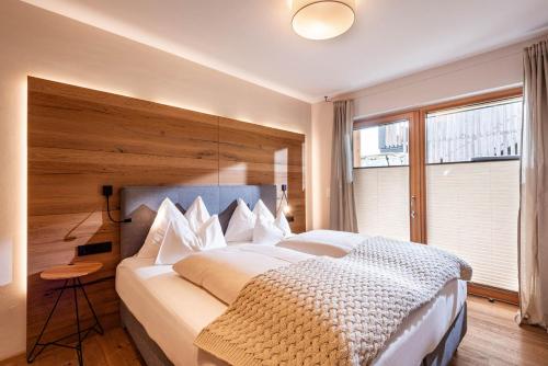 a bedroom with a large bed and a large window at das Luis in Oberndorf in Tirol