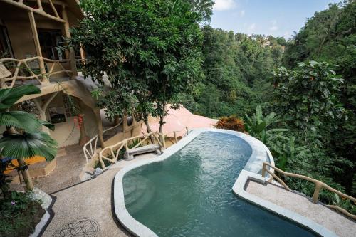 Una piscina al aire libre en un complejo con árboles. en Sacred Mandala retreat center Ubud, en Ubud