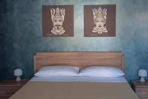 a bedroom with a bed with two posters on the wall at La Terrazza di Porticello in Porticello