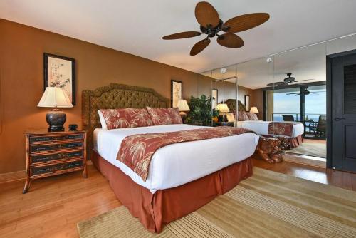 カハナにあるMahana 1008 · MA 1008 Luxury BeachFront Condoのベッド2台と天井ファン付きの寝室