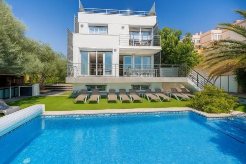 une maison avec une piscine devant une maison dans l'établissement Villa De Lujo Benidorm Vista al mar, à Finestrat
