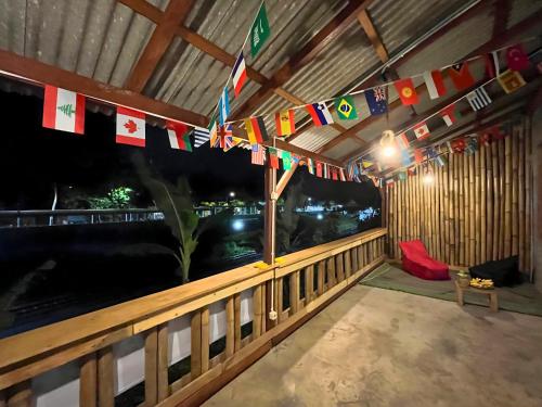 une pièce avec des drapeaux et un balcon avec une table dans l'établissement Ijen Backpacker Atas Angin dekat Stasiun Banyuwangi Kota, à Giri