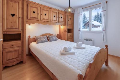a bedroom with a large bed with two towels on it at Alba Lodge, 2 min de la télécabine, vue montagnes in Brides-les-Bains