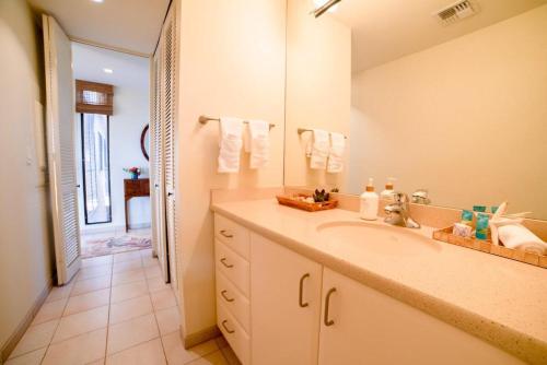 a bathroom with a sink and a large mirror at Wailea Ekahi 17D · WEK 17D Wailea Retreat w Ocean View Pool AC in Wailea