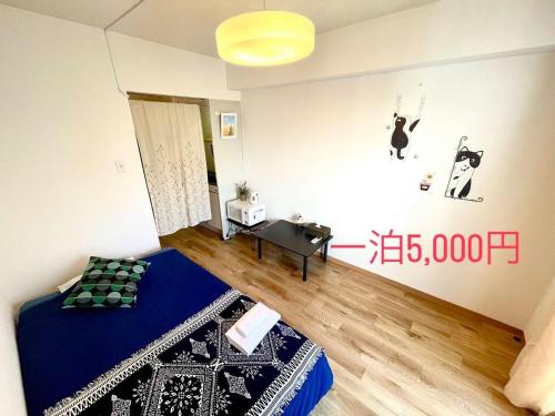 a bedroom with a blue bed and a desk in it at KT-HouSe FUKUOKA311s in Fukuoka