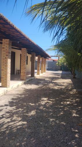a building with brick pillars and a palm tree at Vila São Miguel in Fortim