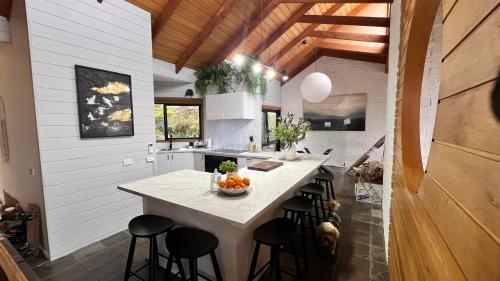a kitchen with a island with a bowl of fruit on it at Ocean Views - Ocean Grove, Spectacular Family Home in sought after Location in Ocean Grove