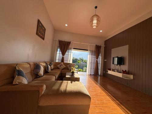 a living room with a couch and a tv at ม่อนหมอกเชียงดาว in Chiang Dao