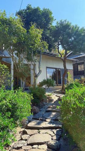 a stone path in front of a house with trees at Okayama Garden House Near Station Free Parking in Okayama