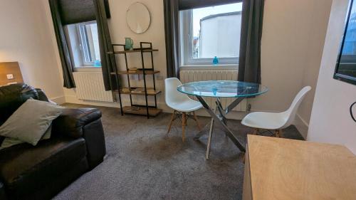 a living room with a glass table and chairs at Captivating 1-Bed apartment Merthyr Tydfil - in Merthyr Tydfil