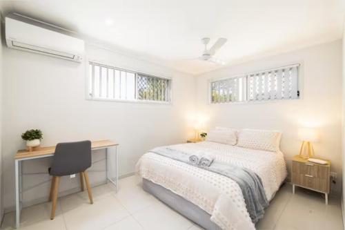 a bedroom with a bed and a desk and windows at Smart Suites Self Check-in Apartments - S Freney in Brisbane