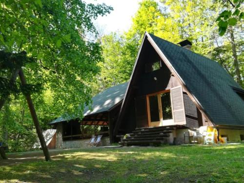 a small house with a gambrel roof at Cottage Koča Oaza Preske in Jurklošter