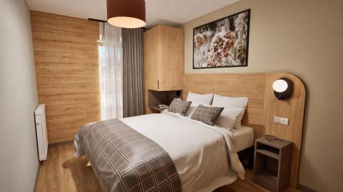 a hotel room with a bed and a window at Résidence Odalys L'Ecrin Blanc in Montvalezan