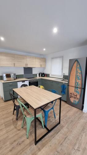 a kitchen with a wooden table and chairs at Spacieux T3 Piscine à Anglet in BIQ