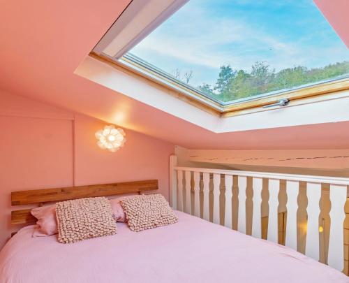 a bedroom with a bed with a skylight at Maison Mori in Vienne