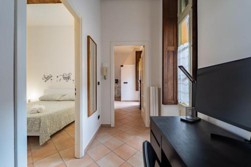 a bedroom with a bed and a tv in a room at La Terrazza in Centro Storico - Free Wifi & AC in Savigliano