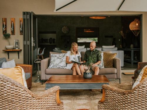 a man and woman sitting on a couch in a living room at Rhino's Rest Private Luxury Villa in Hoedspruit