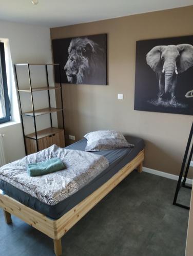 a bed in a bedroom with a picture of a lion at Maison rue des bulles in Pont-à-Mousson