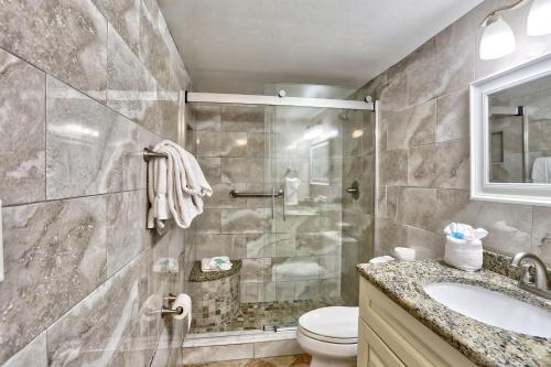 a bathroom with a shower and a toilet and a sink at Sunset Chateau 506 - Premier in St. Pete Beach