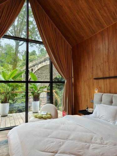 a bedroom with a bed and a large window at VERDANT HAVEN in Jiezi Ancient Town