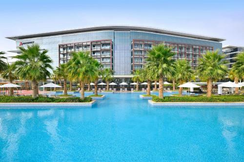 a large building with palm trees in front of it at Marriott Hotel Al Forsan, Abu Dhabi in Abu Dhabi