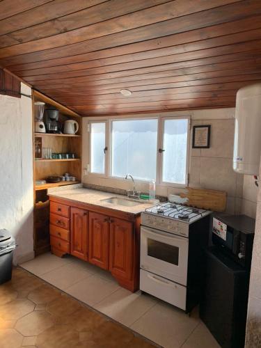 een keuken met een fornuis, een wastafel en een raam bij Complejo Gerar in Las Toninas