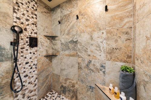a bathroom with a shower with a stone wall at Maui Kaanapali Villas 415 · MKV 415 Updated Condo w Ocean View a in Kahana