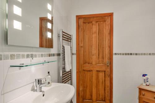 ソルカムにあるFinest Retreats - Furzehillの洗面台と木製のドアのあるバスルーム